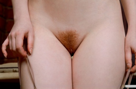 Молодая рыжеволосая Аничка обхватывает грудь, показывая свой подстриженный кустик картинка 5