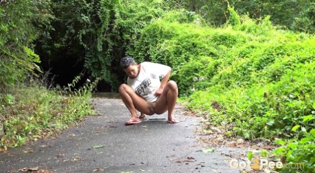 Одинокая женщина Хлоя Ламур мочится на мощеную дорожку в сандалиях картинка 2