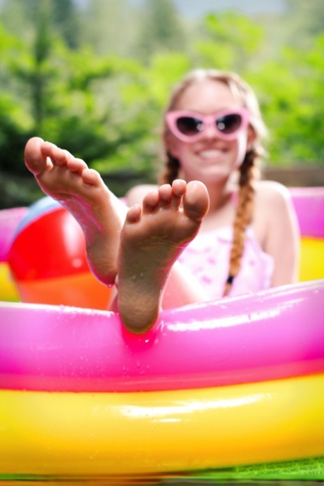 Очаровательная молоденькая Долли Литтл дергает себя за заплетенные косички в надувном бассейне картинка 2