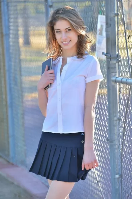 Худенькая девушка демонстрирует свои трусики под юбкой в школьной форме на тротуаре картинка 2