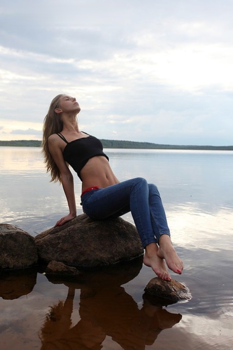 Девушка по соседству Меган показывает свои сиськи, сидя на камне в озере картинка 13