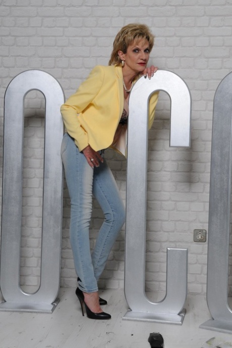 Зрелая британка леди Соня обнажает свои большие сиськи, прежде чем стянуть джинсы картинка 4