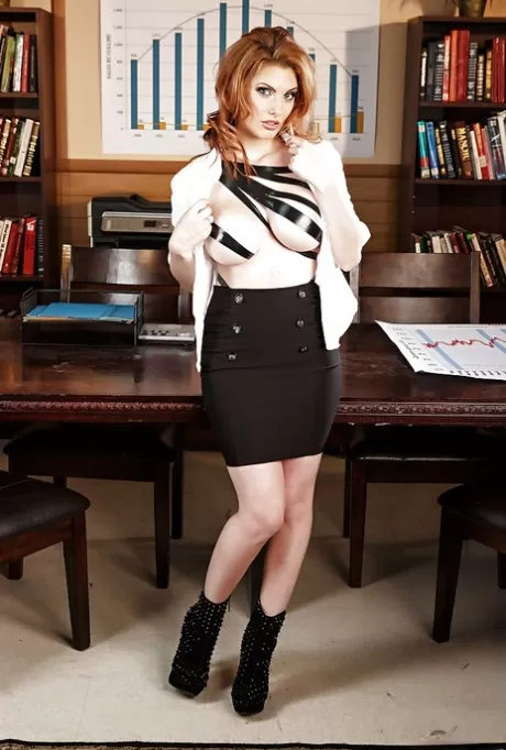 Знойная рыжеволосая красотка раздевается и выставляет напоказ свои товары на своем офисном столе картинка 3