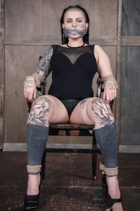 Над девушкой с пирсингом и татуировками работает женщина, пока она находится в рабстве картинка 11