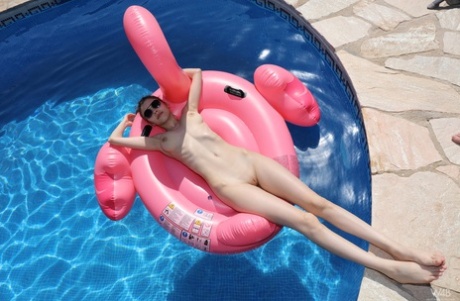 Милая девушка-подросток с большими натуральными сиськами показывает свою лысую пизду на надувном лебеде картинка 16