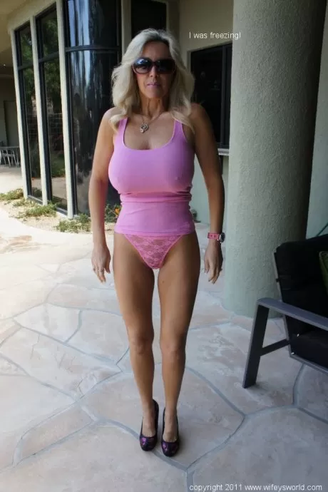 Сладкая грудастая зрелая леди в розовых трусиках позирует жене на открытом воздухе